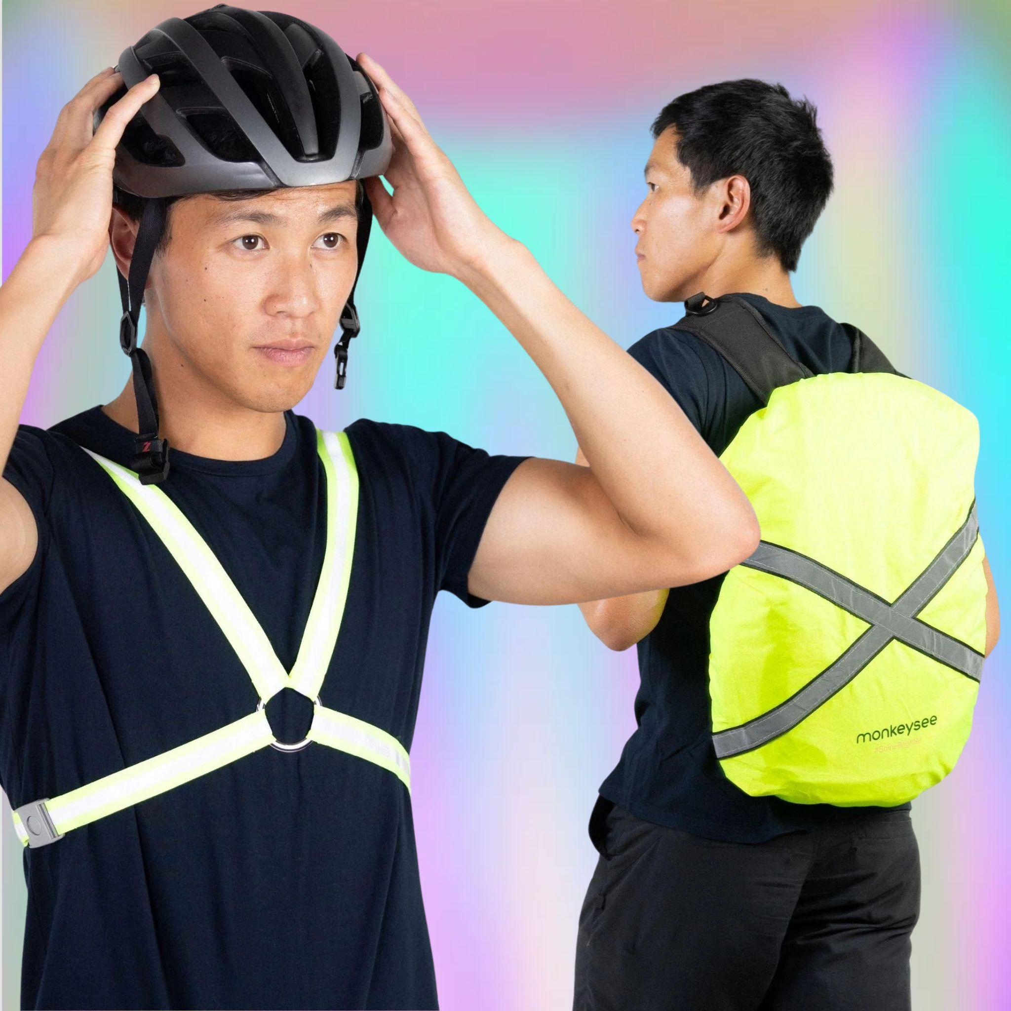 One man wearing reflective cycling harness, a second make with a yellow waterproof cover over his backpack